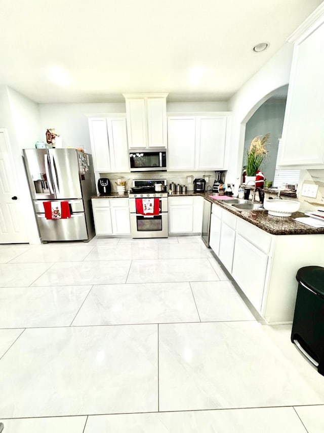 kitchen with stainless steel appliances, white cabinetry, and sink