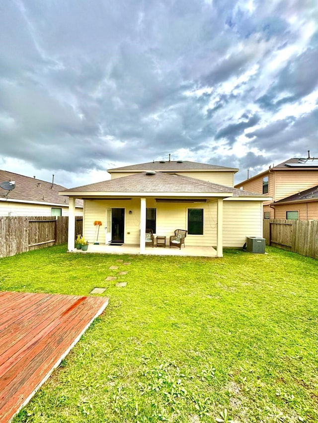 back of property with a yard, central AC, an outdoor hangout area, and a patio area