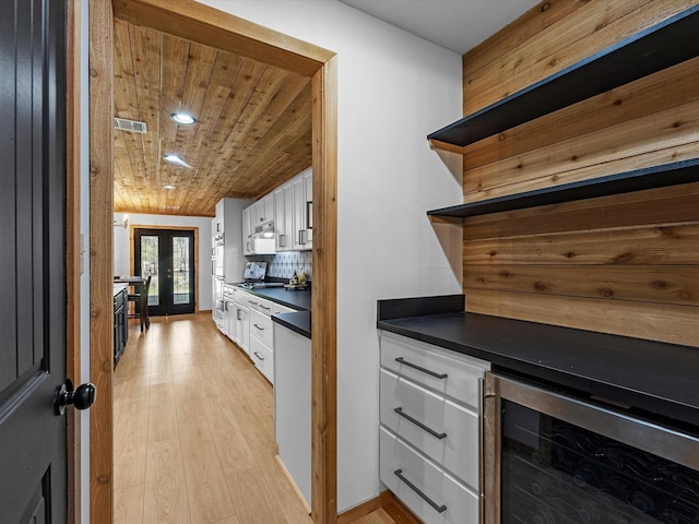 kitchen with white cabinets, wood ceiling, french doors, and tasteful backsplash