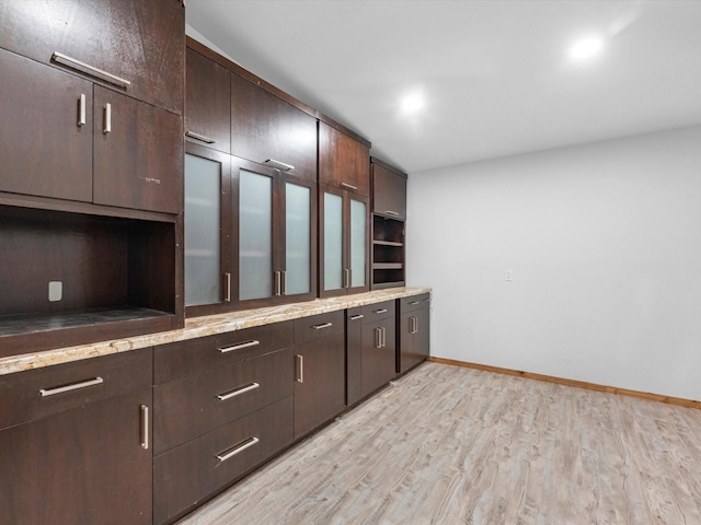 kitchen featuring dark brown cabinetry and light hardwood / wood-style flooring