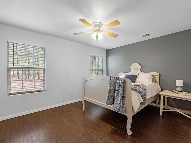 bedroom featuring multiple windows, dark hardwood / wood-style flooring, and ceiling fan