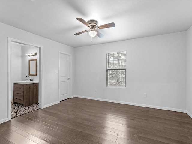 unfurnished bedroom featuring ensuite bathroom, sink, ceiling fan, and dark hardwood / wood-style floors