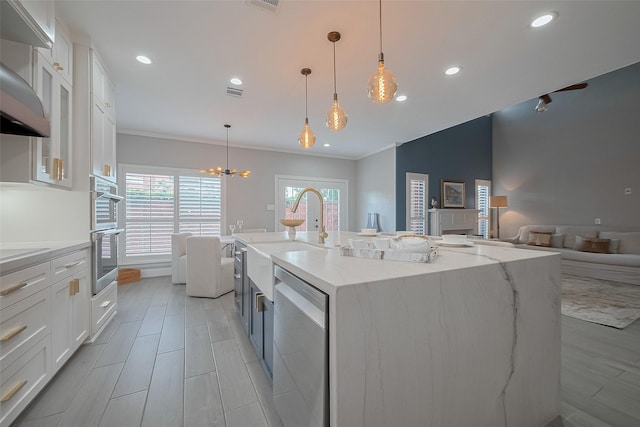 4 Rutgers Pl W, University Place, TX 77005 - kitchen featuring stainless steel appliances, a sink, white cabinetry, ornamental molding, and wall chimney range hood
