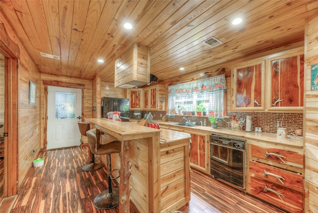 kitchen with wood walls, black refrigerator, wood-type flooring, and wood ceiling