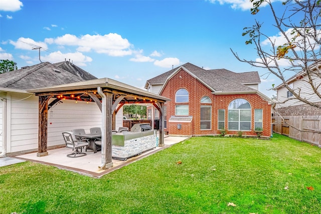 rear view of house with a gazebo, an outdoor kitchen, a yard, and a patio