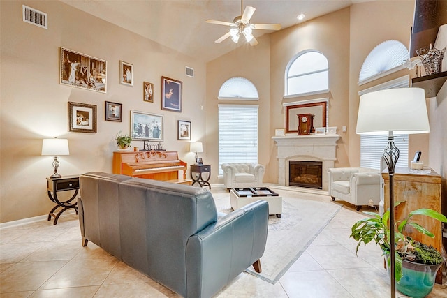 living room featuring ceiling fan, light tile patterned flooring, and a towering ceiling