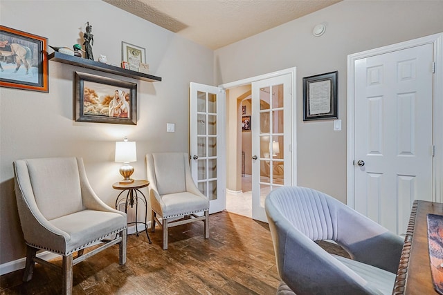 sitting room with french doors and dark hardwood / wood-style floors