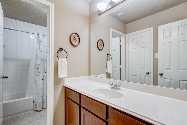 bathroom with tile patterned floors, vanity, shower / bath combo, and a textured ceiling