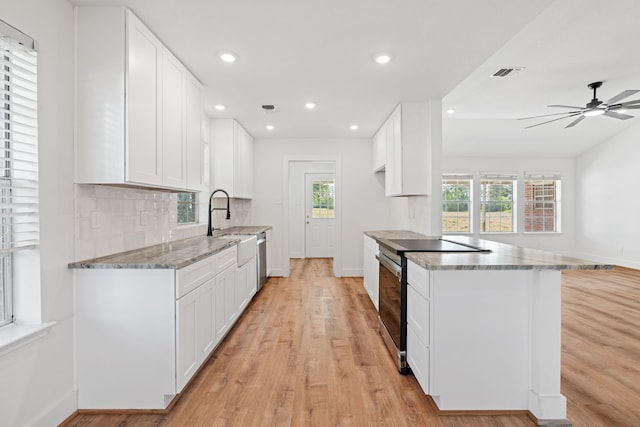 kitchen featuring light stone counters, white cabinetry, and stainless steel appliances