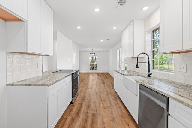 kitchen with white cabinets, light stone counters, sink, and stainless steel appliances