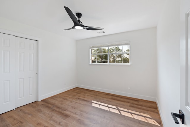 unfurnished bedroom with a closet, light hardwood / wood-style flooring, and ceiling fan