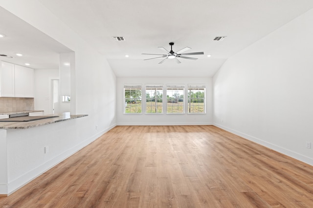 unfurnished living room featuring ceiling fan, light wood-type flooring, and lofted ceiling