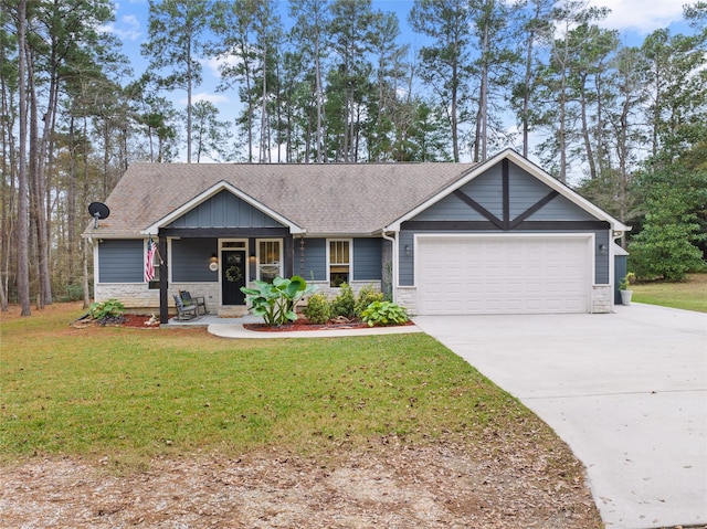 view of front of house with a porch, a front yard, and a garage