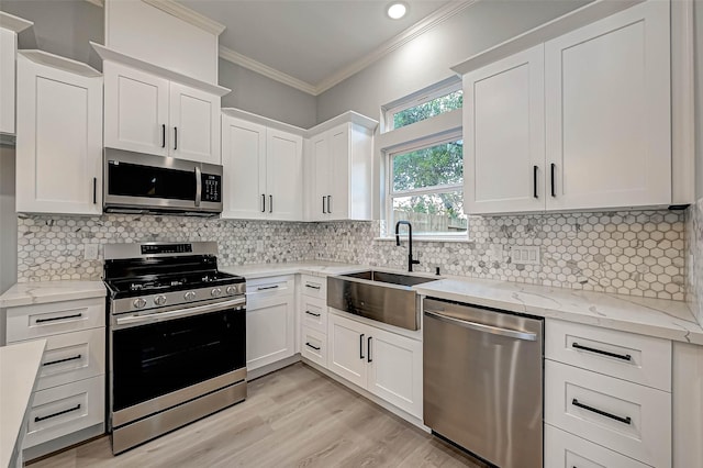 kitchen with white cabinets, backsplash, sink, and stainless steel appliances