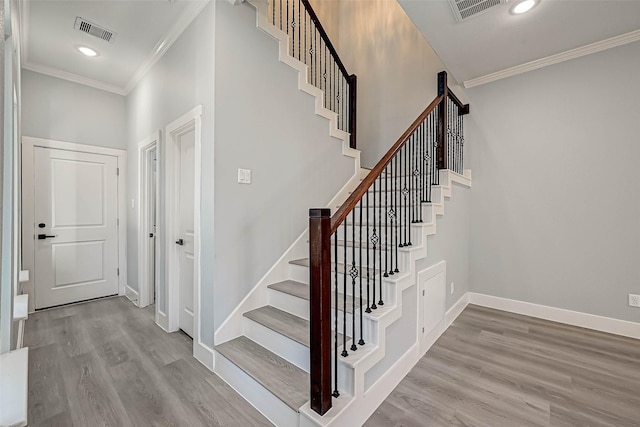 stairway featuring crown molding and hardwood / wood-style flooring