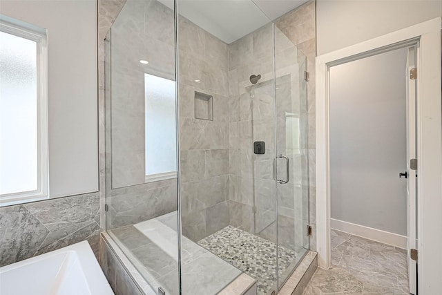 bathroom with a healthy amount of sunlight and independent shower and bath