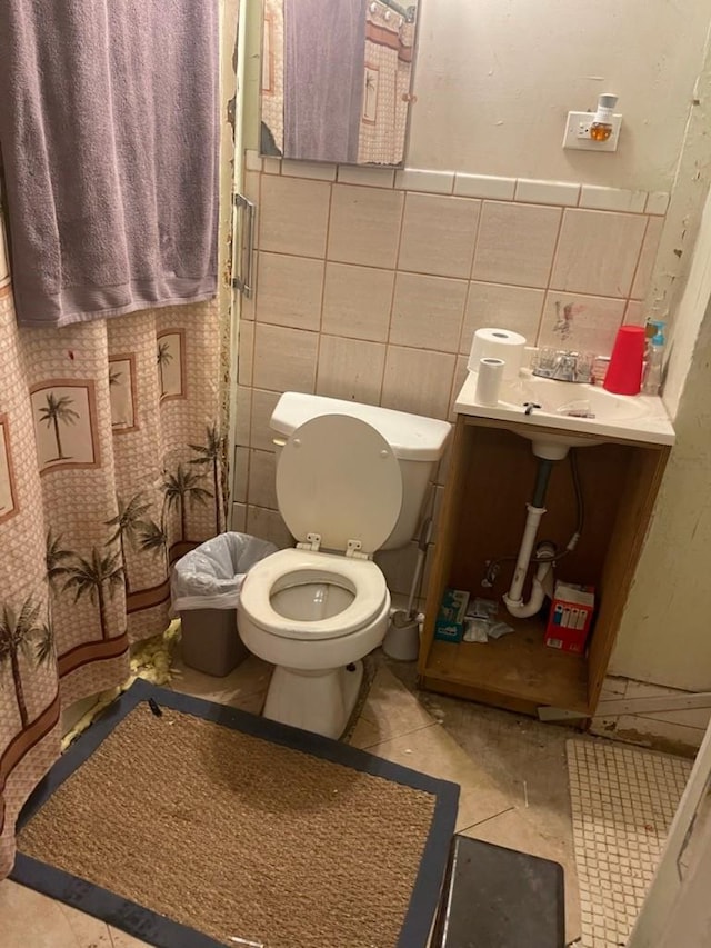 bathroom featuring tile patterned flooring, tile walls, and toilet