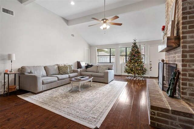 living room featuring dark wood-type flooring, high vaulted ceiling, ceiling fan, a fireplace, and beamed ceiling