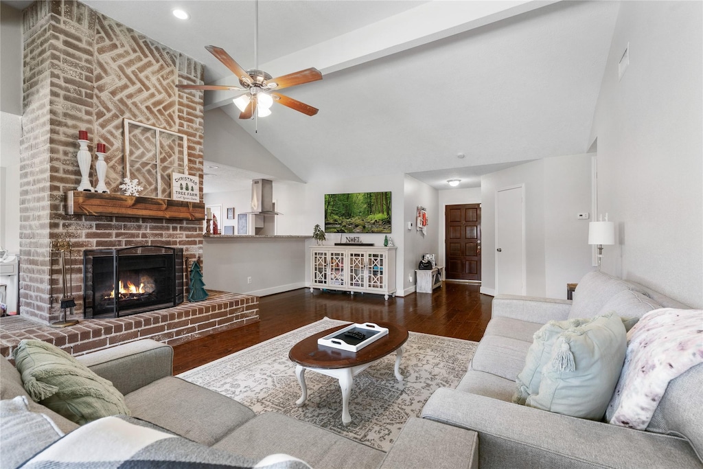 living area featuring baseboards, dark wood finished floors, ceiling fan, a fireplace, and high vaulted ceiling