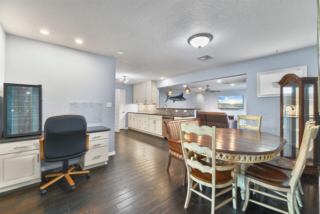 dining area featuring dark hardwood / wood-style flooring, a textured ceiling, ceiling fan, and sink