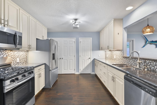 kitchen featuring tasteful backsplash, dark hardwood / wood-style flooring, sink, and appliances with stainless steel finishes