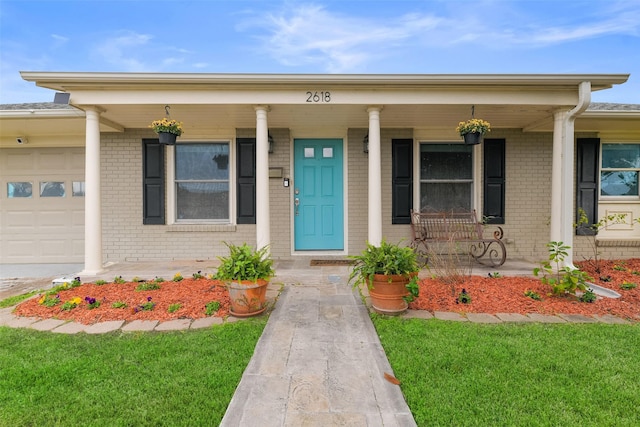 property entrance featuring a yard, a porch, and a garage