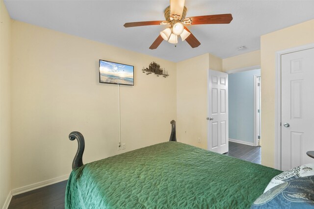 unfurnished bedroom with ceiling fan and dark wood-type flooring