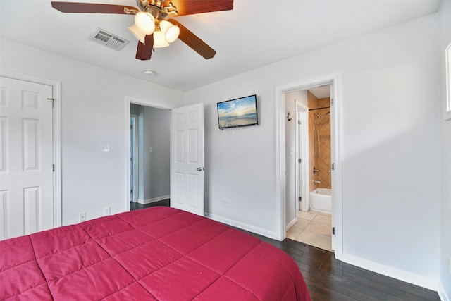 bedroom with ceiling fan, dark wood-type flooring, and ensuite bathroom