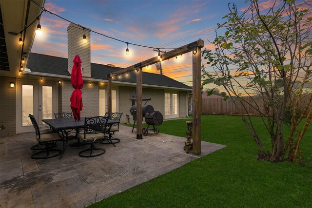 patio terrace at dusk with french doors and a yard