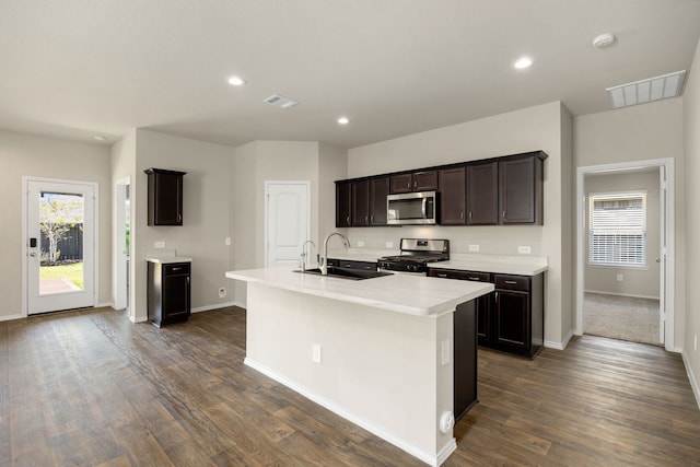 kitchen featuring dark brown cabinets, stainless steel appliances, sink, a center island with sink, and dark hardwood / wood-style floors