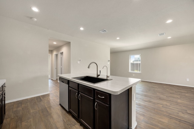 kitchen with dark brown cabinetry, sink, dark hardwood / wood-style flooring, stainless steel dishwasher, and a center island with sink