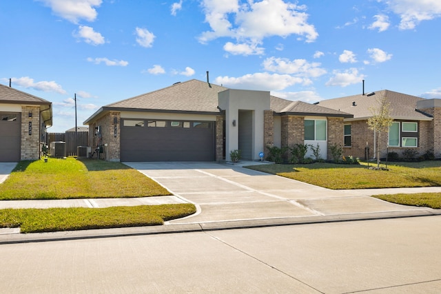 view of front facade featuring a front lawn, concrete driveway, an attached garage, and central AC unit