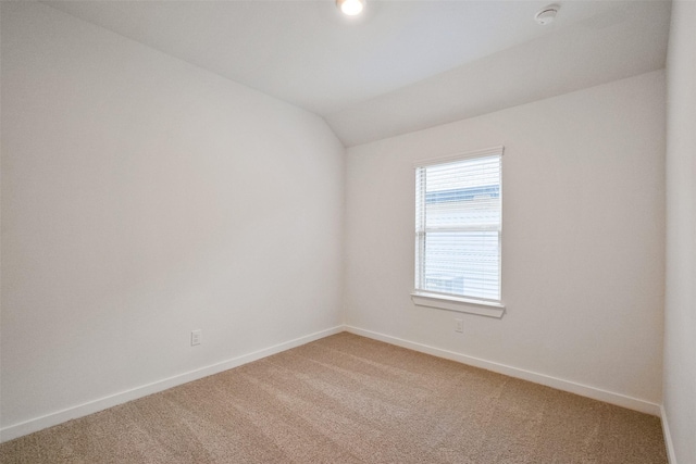 carpeted empty room with lofted ceiling