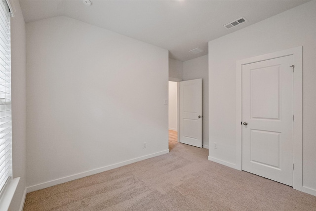 unfurnished bedroom featuring light carpet and multiple windows