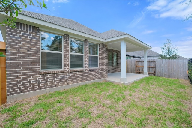 back of house featuring a lawn and a patio area