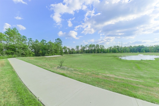 view of community with a water view and a lawn