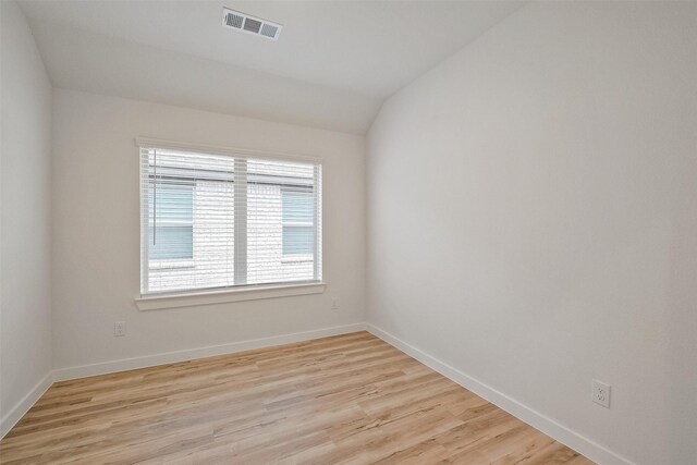 empty room featuring light hardwood / wood-style flooring and lofted ceiling