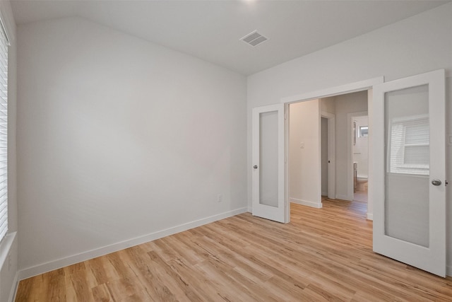 unfurnished room with light hardwood / wood-style floors and french doors