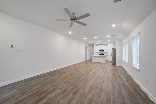 unfurnished living room featuring wood-type flooring and ceiling fan