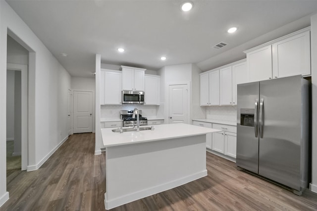 kitchen featuring white cabinetry, appliances with stainless steel finishes, dark wood-type flooring, and a center island with sink