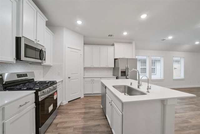 kitchen featuring white cabinetry, sink, an island with sink, and appliances with stainless steel finishes