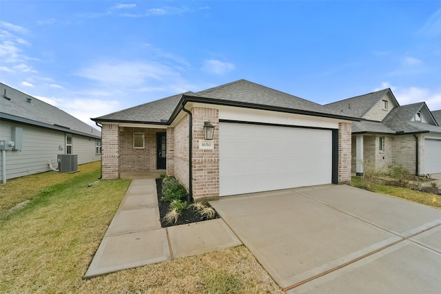 view of front of home with a garage, central AC, and a front yard