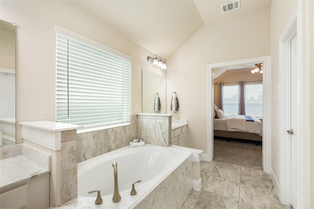 bathroom featuring tiled bath, ceiling fan, vanity, and vaulted ceiling