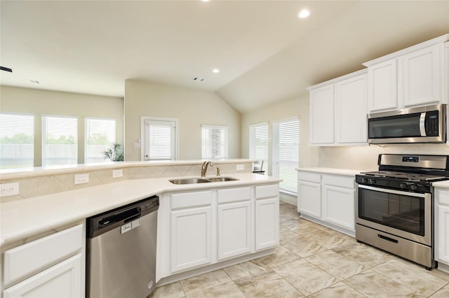 kitchen featuring sink, white cabinets, vaulted ceiling, and appliances with stainless steel finishes