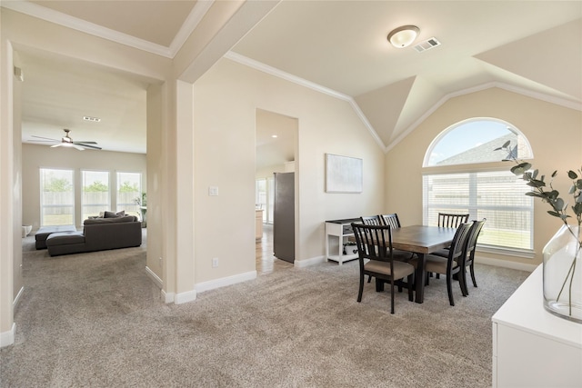 carpeted dining room with ceiling fan, lofted ceiling, and crown molding