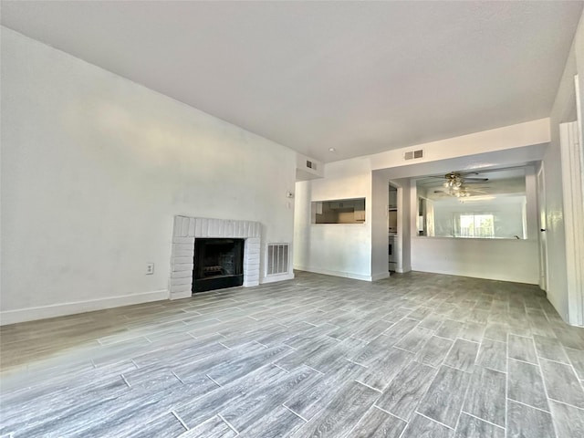 unfurnished living room with ceiling fan and a fireplace