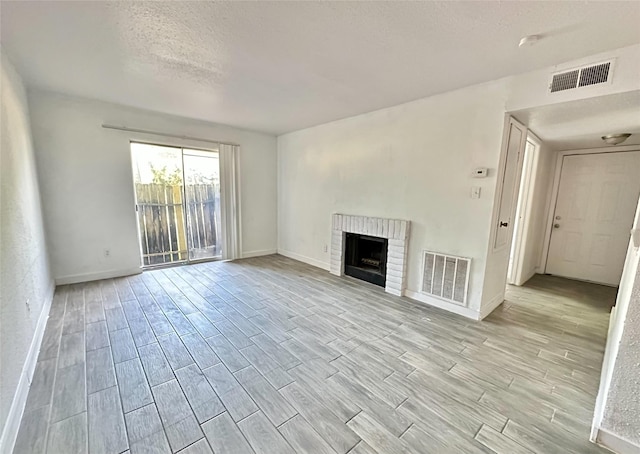 unfurnished living room with a textured ceiling and a fireplace