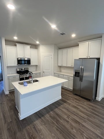 kitchen featuring white cabinetry, sink, dark wood-type flooring, tasteful backsplash, and appliances with stainless steel finishes