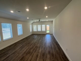 unfurnished living room featuring a healthy amount of sunlight and dark wood-type flooring