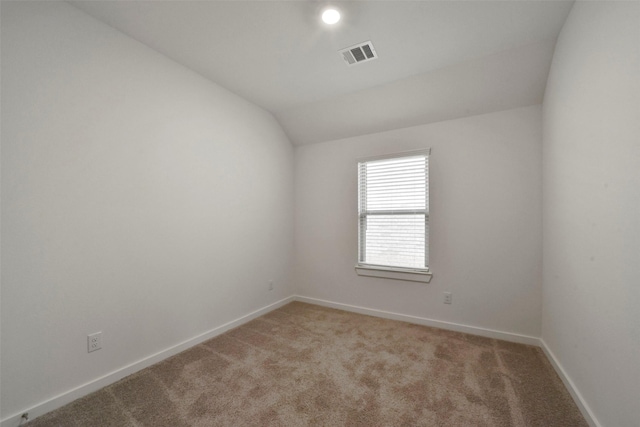 empty room featuring light carpet and lofted ceiling